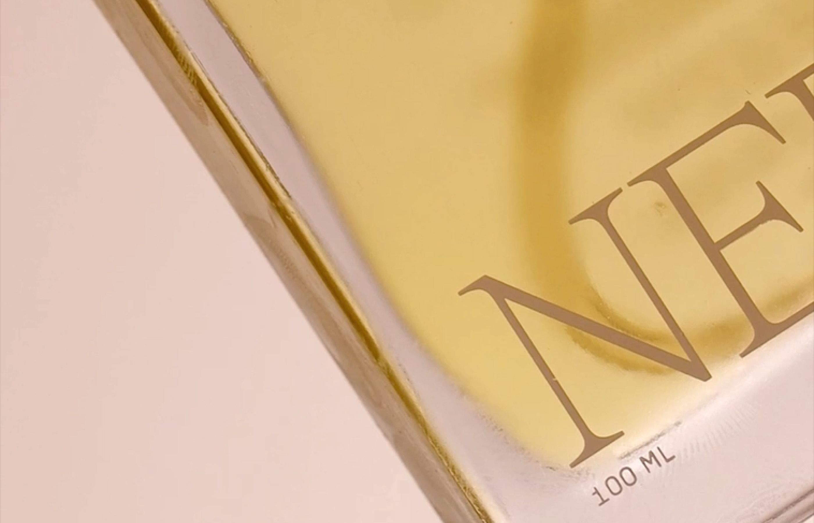 Close-up of Nerra perfume bottle with golden oil reflections