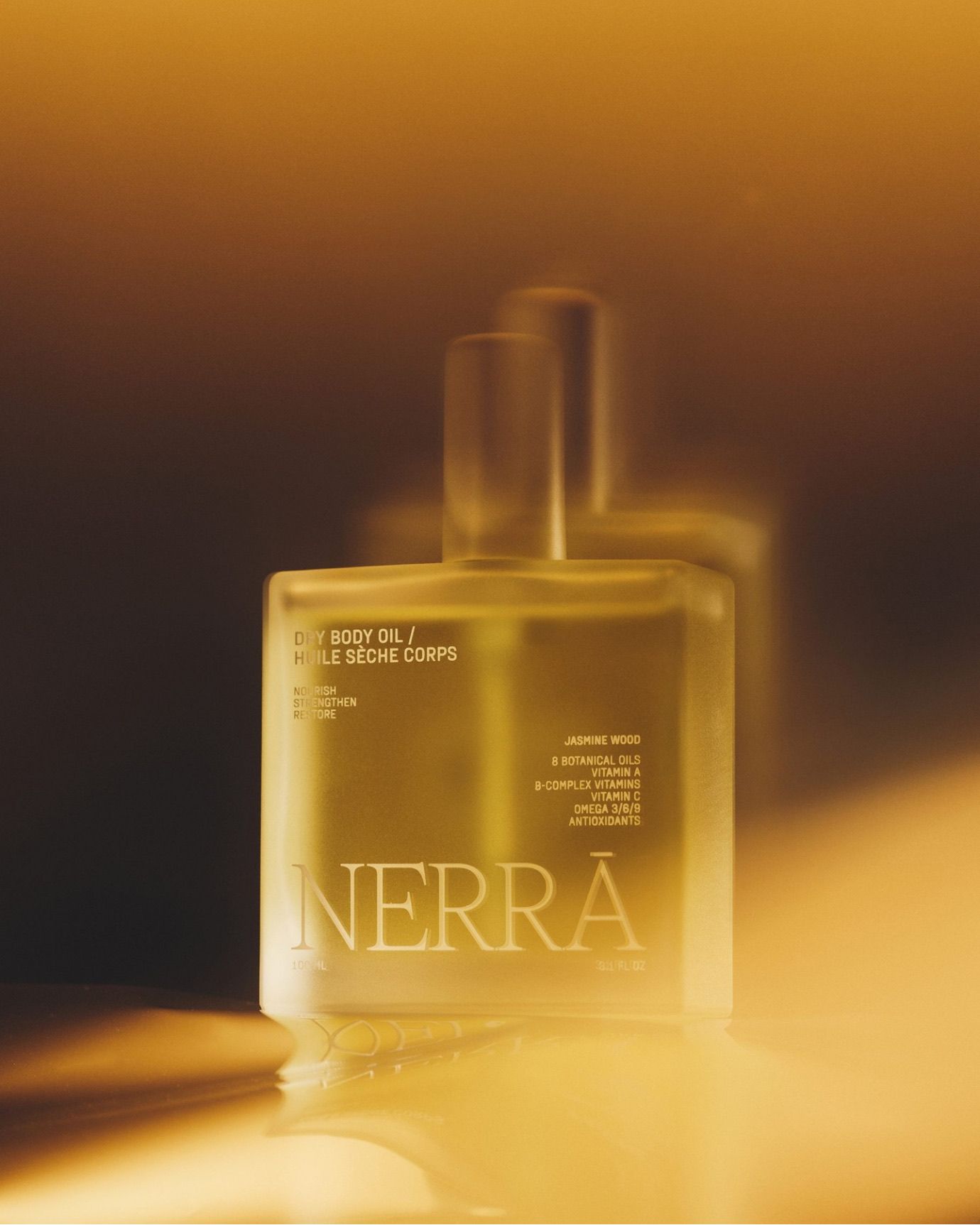Nerra dry body oil bottle in warm golden ambient lighting
