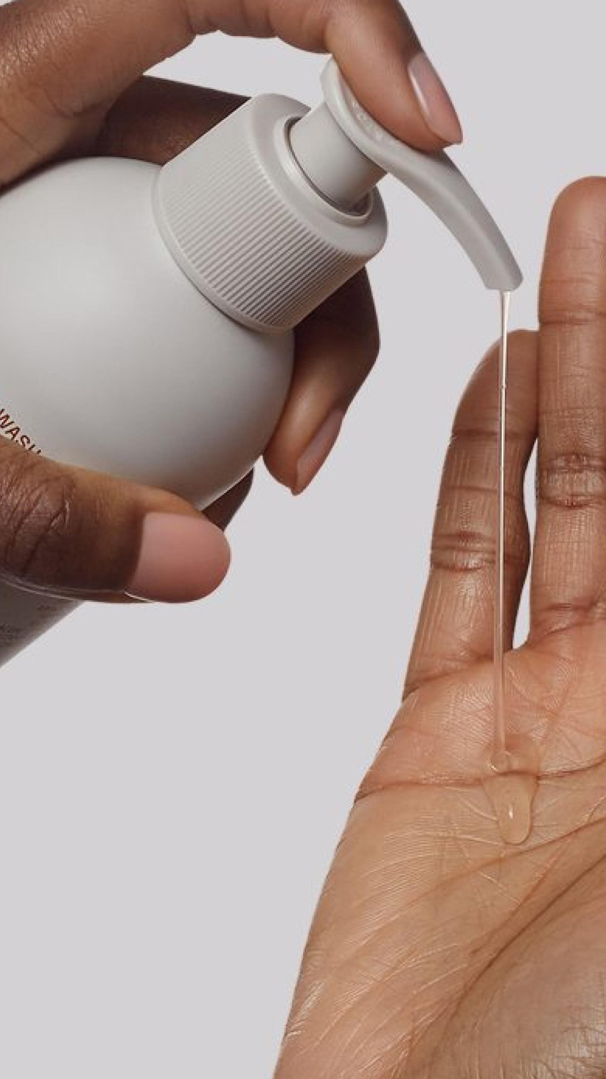 Nerra body wash product being dispensed onto a hand, close-up shot